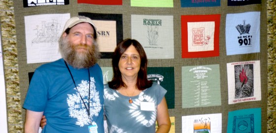 June 27, Urbana, Illinois – Norman Stockwell, WORT (Madison, WI) Operations Coordinator with Pacifica Affiliates Coordinator Ursula Ruedenberg, in front of the GRC Community Radio Quilt. Stockwell had just received Pacifica Network’s Annual GRC Outstanding Service to Community Radio at the Pacifica Affiliates Meeting during GRC Conference.